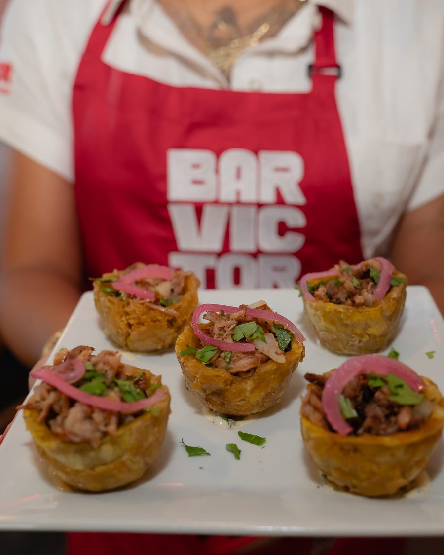 Tostón nacho cups topped with shredded pork and pickled onion
